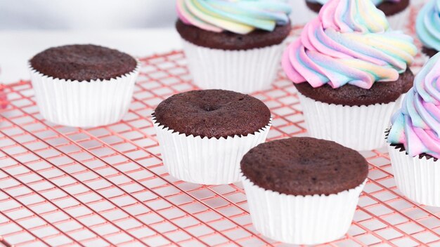 Paso a paso. Glaseado de cupcakes de chocolate unicornio con glaseado de crema de mantequilla de color arcoíris.