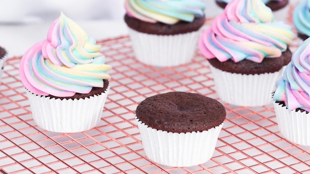 Paso a paso. Glaseado de cupcakes de chocolate unicornio con glaseado de crema de mantequilla de color arcoíris.