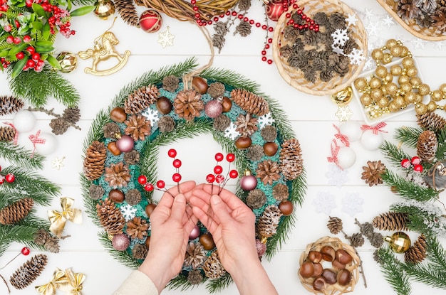 Paso a paso para hacer una gran corona de Navidad, paso 13: tome bayas artificiales en un alambre