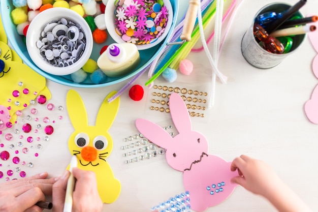 Foto paso a paso. madre e hija decorando conejitos de pascua.