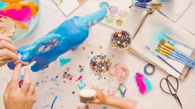 Paso a paso. Madre e hija decorando unicornio de papel maché juntas.