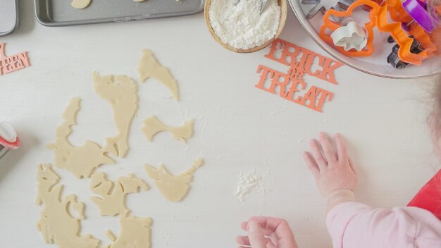 Paso a paso. Madre e hija haciendo galletas de azúcar de Halloween.