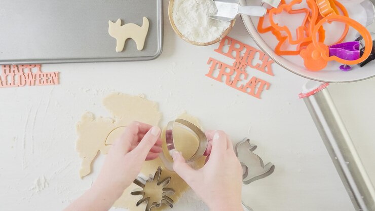 Foto paso a paso. madre e hija haciendo galletas de azúcar de halloween.