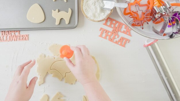 Paso a paso. Madre e hija haciendo galletas de azúcar de Halloween.