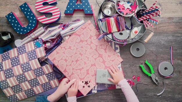 Paso a paso. Madre e hija haciendo petardos de papel para la celebración del 4 de julio.