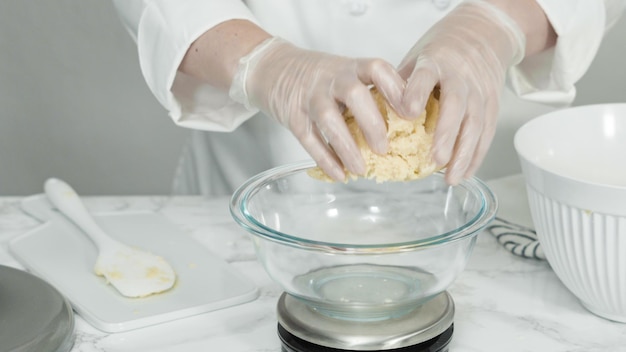 Paso a paso. Medición de la masa de galletas con una báscula de cocina digital para hornear galletas de azúcar de molinillo rojas, blancas y azules.