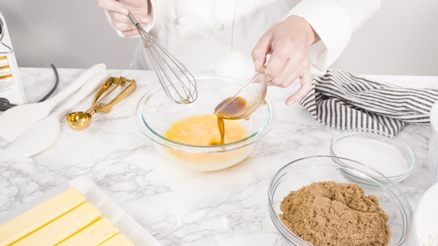 Paso a paso. Mezclar ingredientes en un recipiente de vidrio para hacer galletas con trocitos de chocolate.