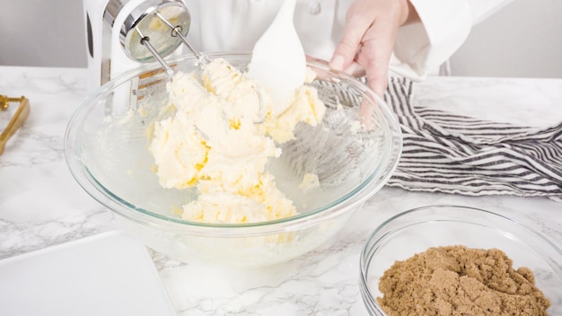 Paso a paso. Mezclar ingredientes en un recipiente de vidrio para hacer galletas con trocitos de chocolate.