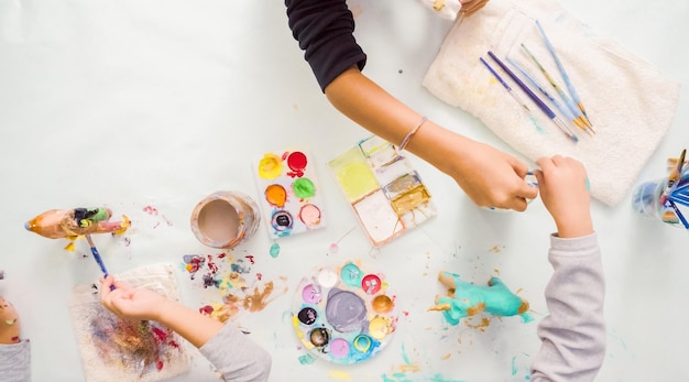 Paso a paso. Niñas pintando unicornios de papel maché con pintura acrílica.