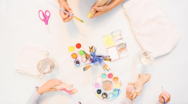 Paso a paso. Niñas pintando unicornios de papel maché con pintura acrílica.