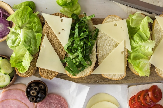 Paso a paso. Preparación de sub sándwich fresco sobre blanco y hoagies de trigo.