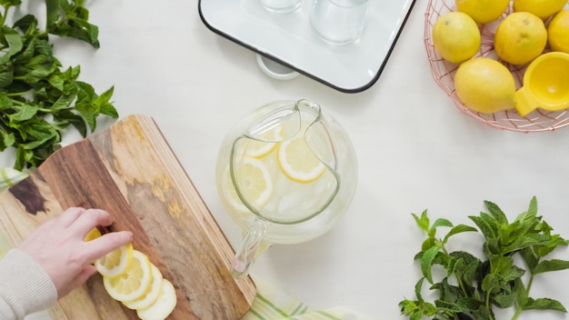 Paso a paso. Preparar limonada tradicional con limones frescos en rodajas y menta.