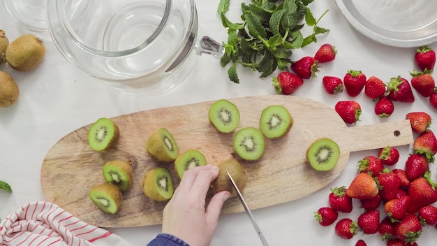 Paso a paso. Rebanar frutas orgánicas frescas para agua infundida.