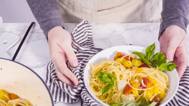 Foto paso a paso. sirviendo una pasta de una olla en un plato de pasta blanca.