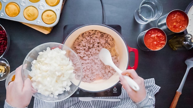 Paso a paso. Vista superior. Cocinar chili de pavo en horno holandés cubierto de hierro fundido esmaltado.