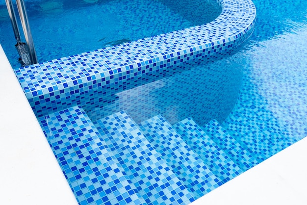 Pasos en la piscina con mosaico de cerámica azul Relajarse en el patio trasero de una casa de campo