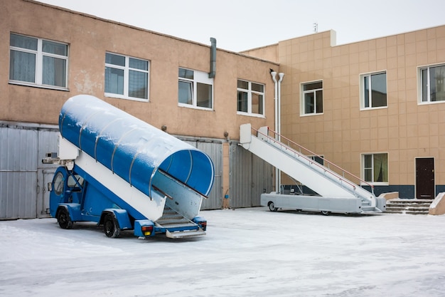 Foto passageiros de embarque em veículos próximos a garagens no aeroporto frio de inverno