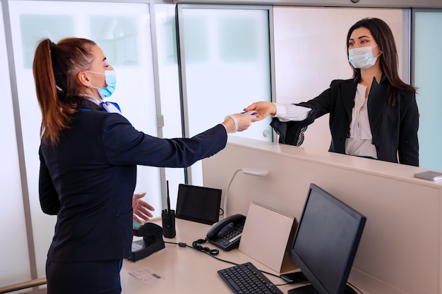 Foto passagier, der dem flughafenmanager seine dokumente zum einchecken am schalter übergibt