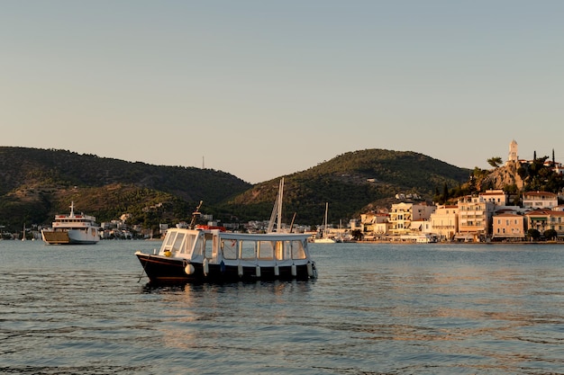 Passagierboot im Meer auf dem Hintergrund der Saronischen Insel Poros Griechenland in den Strahlen der untergehenden Sonne an einem SommerabendxDxA