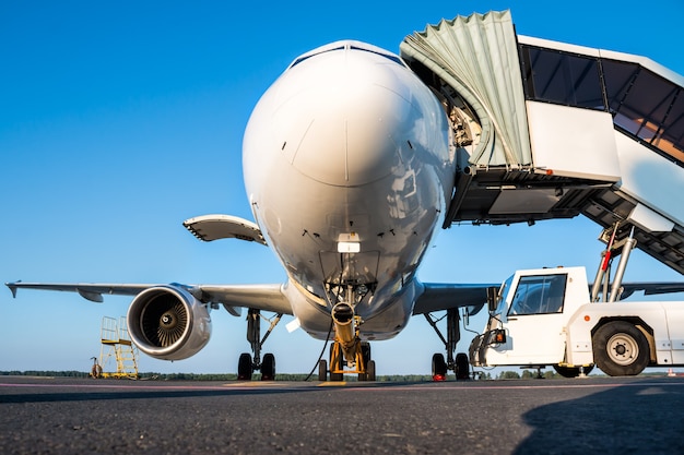 Passagierflugzeug mit offenem Gepäckraum und Einstiegstreppe am Flughafenvorfeld