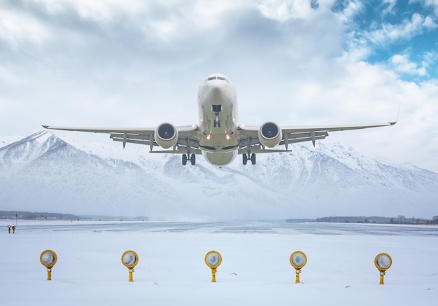 Passagierflugzeugstart von der Landebahn des Winterflughafens vor dem Hintergrund malerischer Berge