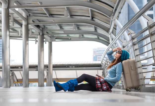 Passagierreisendfrau im Flughafenwarteflugzeugverkehr unter Verwendung des intelligenten Telefons der Tablette.