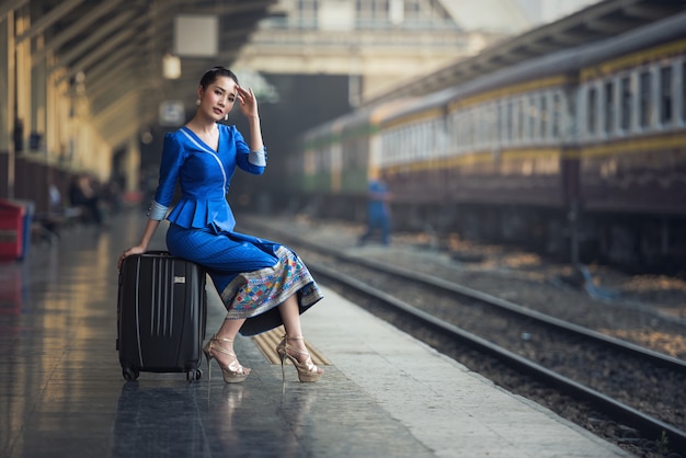 Passagierreisendfrau in der Bahnstation, die auf Reise wartet.