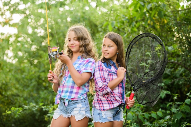 Passando um bom tempo. fim de semana de férias de verão. Peixe voador. crianças pequenas passam tempo no acampamento. se divertindo. pescador de peixe. duas meninas pescando. Pesca desportiva. passatempo de verão. crianças felizes com rede e vara.