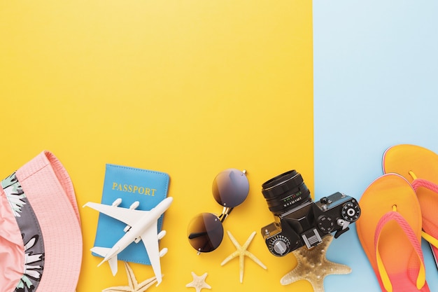 Passaporte, avião de brinquedo, câmera e acessórios de lazer em fundo colorido com espaço de cópia