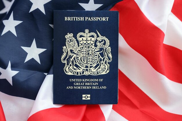 Passaporte britânico azul no fundo da bandeira nacional dos Estados Unidos em close-up
