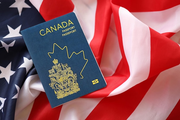 Passaporte canadense em fundo da bandeira nacional dos Estados Unidos close up conceito de turismo e diplomacia
