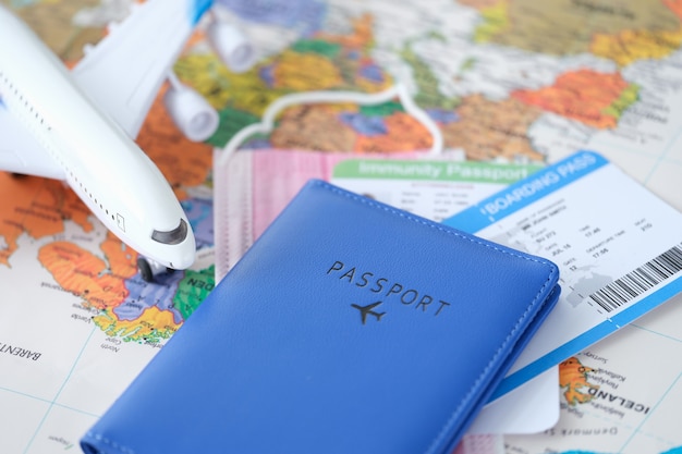 Passaporte com passagens de avião de brinquedo e certificado de vacinação cobiçado estão no mapa do mundo para uma viagem segura