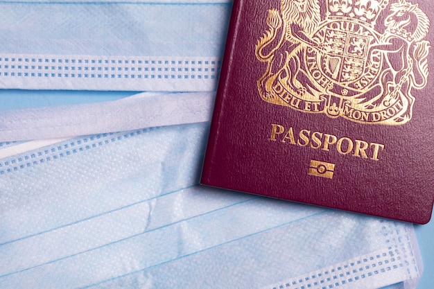 Passaporte de viagem britânico com um conceito de viagem de coronavírus de máscara facial protetora