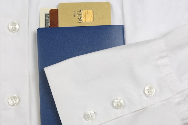 Passaporte, dinheiro e cartões bancários estão em uma camisa branca com mangas