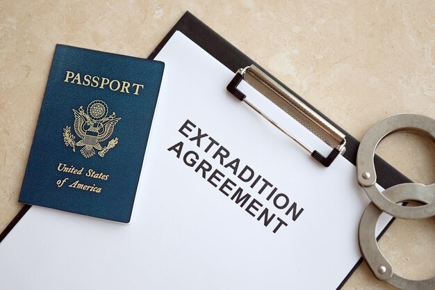 Foto passaporte dos estados unidos e acordo de extradição com algemas na mesa de perto