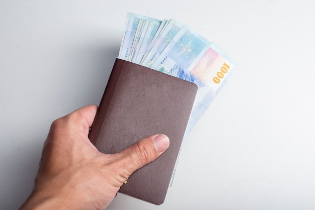 Passaporte e 1000 nova conta de dólar de Taiwan em fundo branco