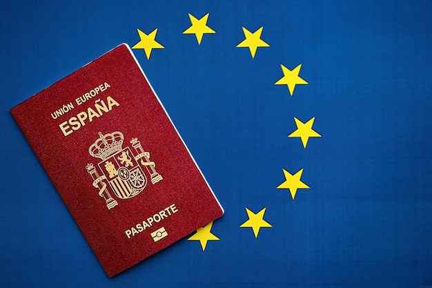 Foto passaporte espanhol vermelho da união europeia em fundo de bandeira azul em close-up