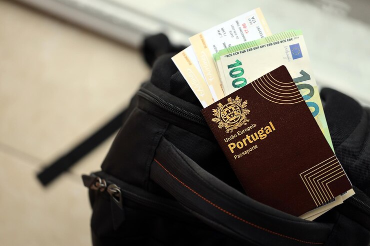 Foto passaporte português vermelho da união europeia com dinheiro e bilhetes de avião numa mochila turística