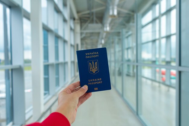 Passaporte ucraniano em mãos no aeroporto antes da partida. Tempo de viagem.