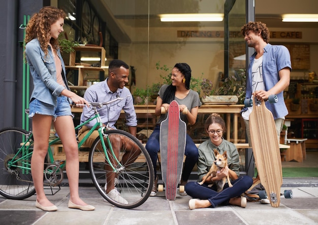 Passar com os amigos é sempre divertido Uma foto de cinco jovens amigos do lado de fora de um café