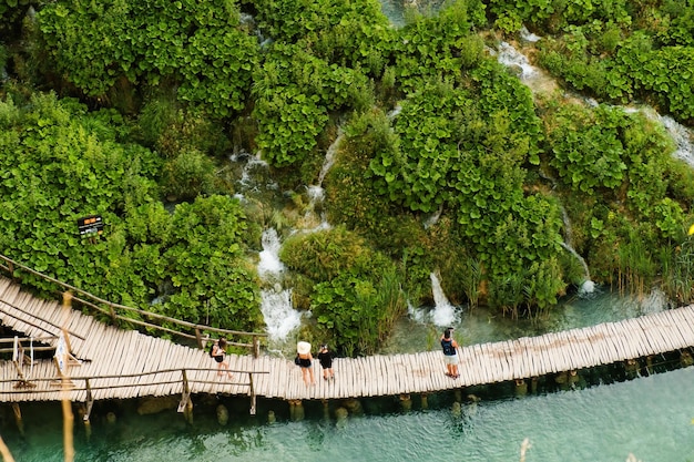 Passarela turística de madeira ao longo do lago azul no parque natural