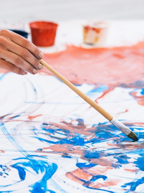 Passatempo de arte Habilidade criativa Talento imaginação Artista feminina pintura à mão colorida azul vermelho padrão abstrato arte acrílica com pincel na tela de papel branco