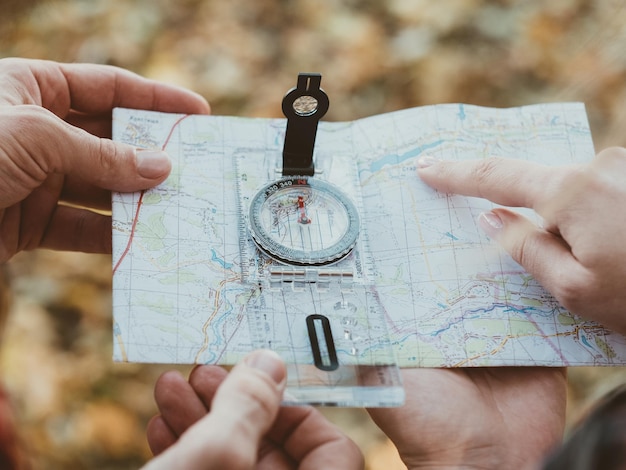 Passatempo de turismo de caminhada Foto recortada de viajantes usando bússola e mapa para explorar o país