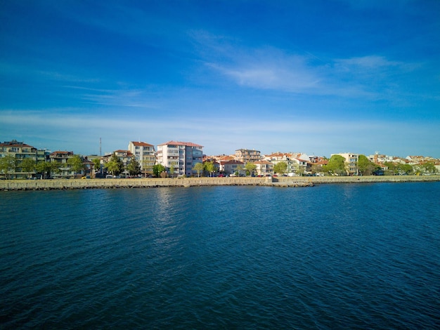 Passeio com pessoas andando perto do Mar Negro contra o pano de fundo da cidade Pomorie na Bulgária sob um céu nublado