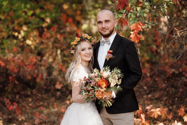 Passeio da noiva e do noivo pela floresta de outono