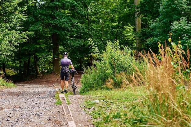 Passeio de atelete de bicicleta em floresta de montanha