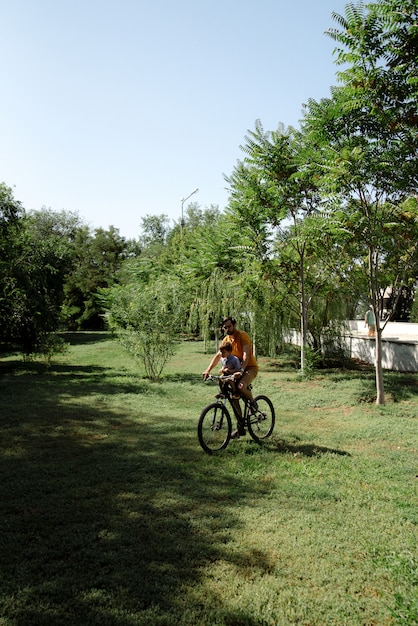 Passeio de bicicleta do pai e do filho na cadeira de bebê