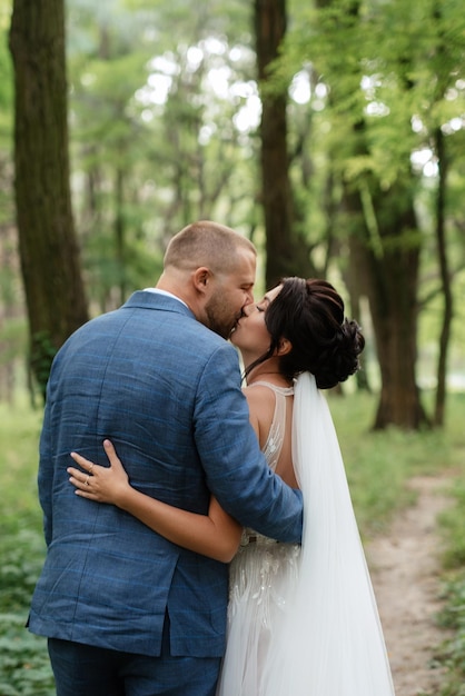 Passeio de casamento dos noivos na floresta decídua no verão