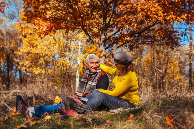 Foto passeio de outono casal de idosos sentado no parque homem e mulher relaxando ao ar livre desfrutando da natureza