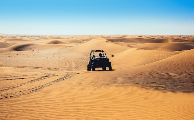 Passeio de quadriciclo de buggy na areia do deserto dos Emirados Árabes Unidos, deixando rastros fora da estrada